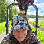 Scruff Mcgruff joined the competition — help win amazing prizes! brown_dog, camouflage, collar, dog, greenery, happy, hat, hoodie, man, nature, outdoor, pet, portrait, road, selfie, shoulders, sky, smile, sunny, trees