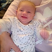 Octavia joined the competition — help win amazing prizes! baby, smiling, onesie, infant, hand, person, clothing, pattern, stars, moons, sleepwear, cute, child, indoor, portrait, happy, young, human, blur, fabric