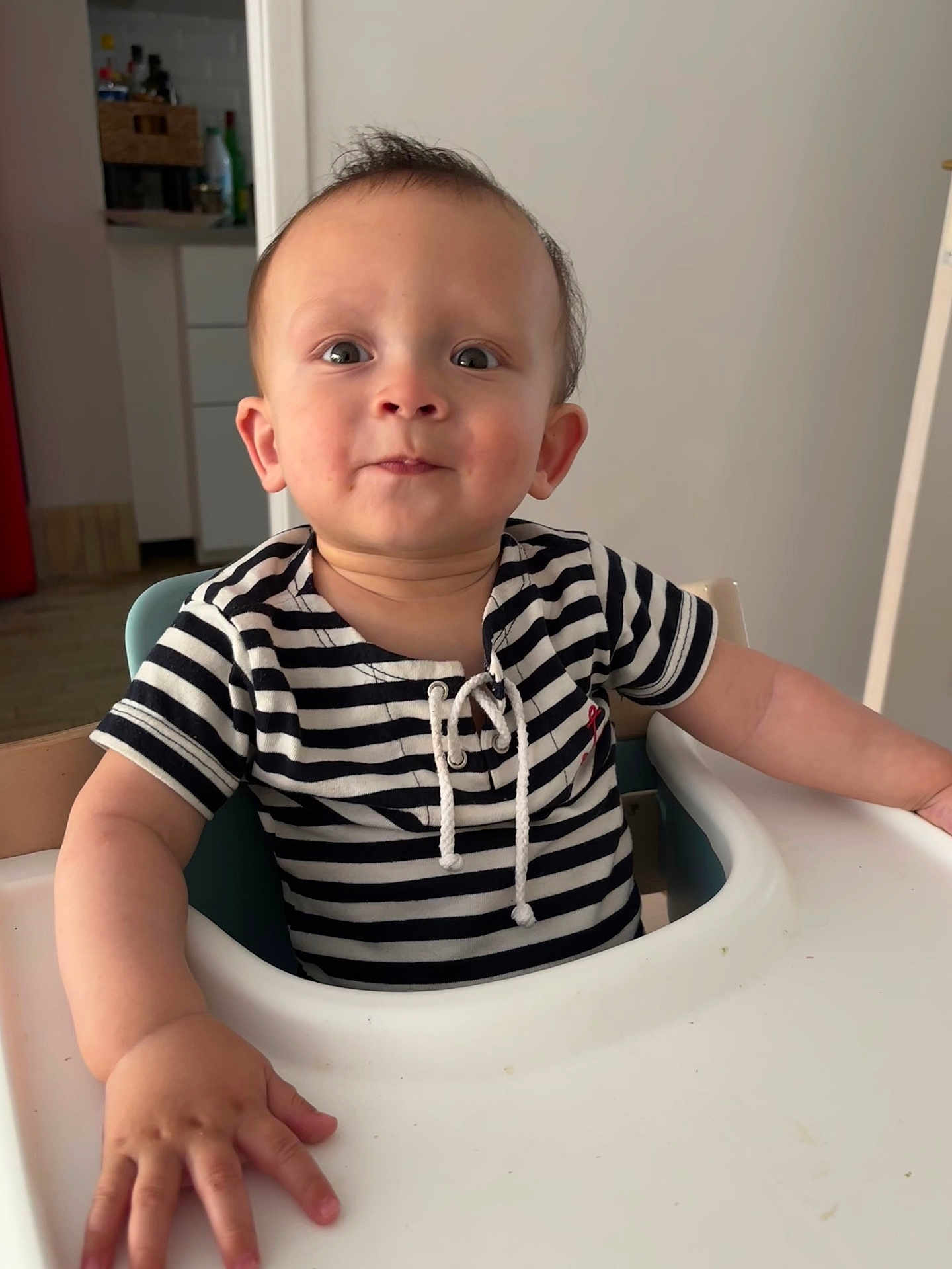 Nathan participe au concours pour gagner de l'argent avec cette photo : toddler, child, high_chair, striped_shirt, indoor, kitchen, baby, person, face, hand, curious, sitting, young_child, furniture, home, expression, cute, casual_clothing, portrait, infant