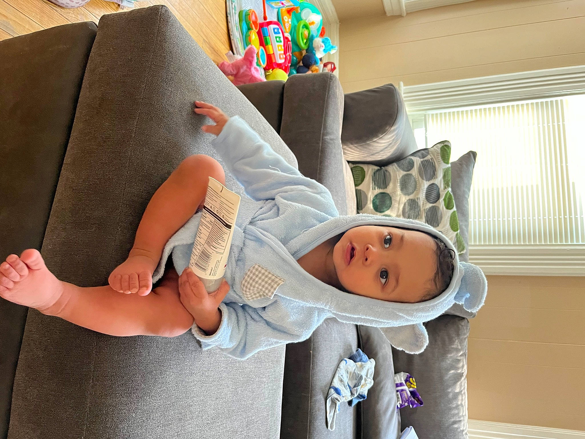 Leonel is registered to the contest to win money with this photo: arm, baby, baby_products, chair, child, comfort, fun, happy, hat, lap, linens, person, pillow, room, sock, textile, throw_pillow, toddler, window, window_blind