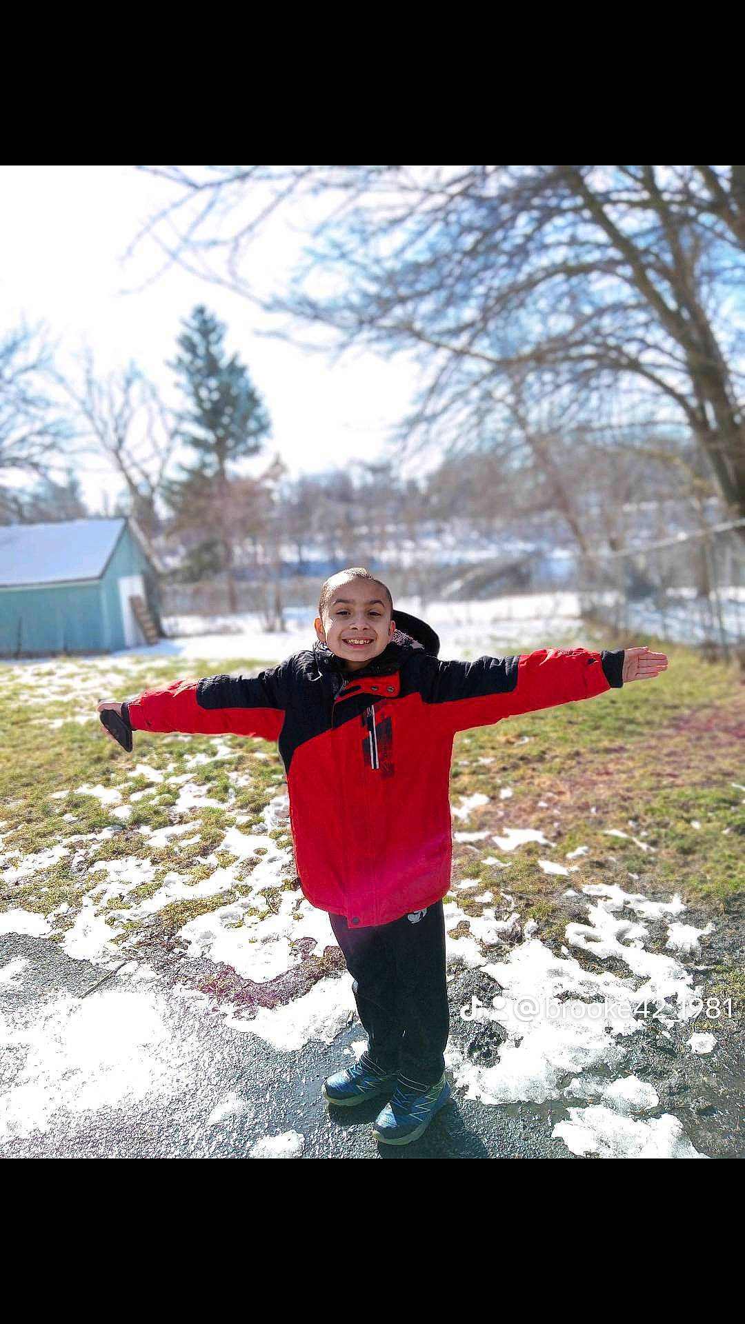 Julian is registered to the contest to win money with this photo: child, flash_photography, freezing, fun, gesture, grass, happy, headwear, jacket, joy, landscape, leisure, people_in_nature, person, plant, playing_in_the_snow, recreation, sky, smile, snow