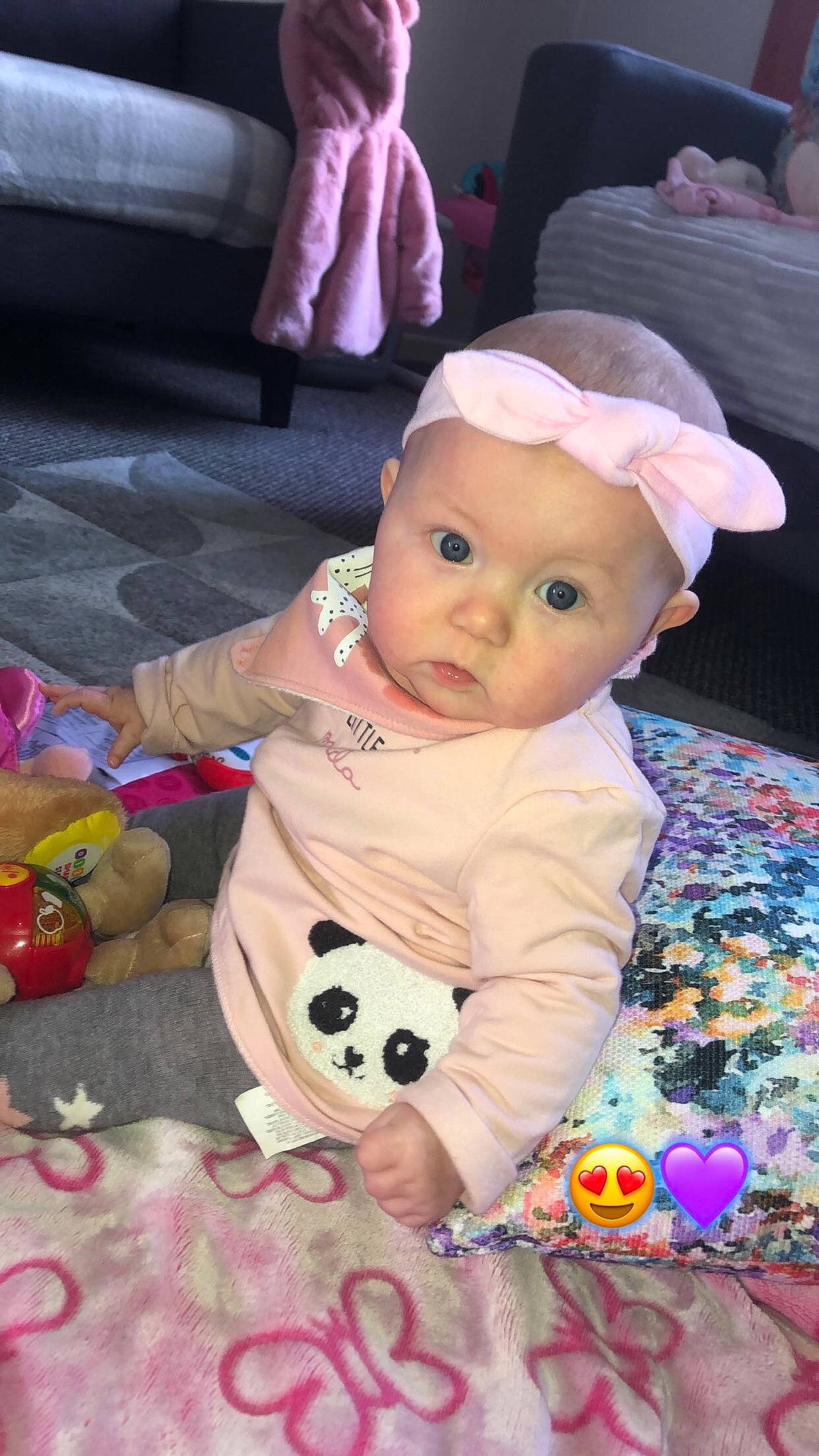 Gia is registered to the contest to win money with this photo: baby, baby_products, baby_toddler_clothing, baby_toys, carmine, cheek, child, comfort, flooring, fun, happy, headwear, lap, linens, person, pink, play, room, sitting, stuffed_toy