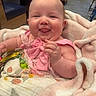 Guinevere is registered to the contest to win money with this photo: baby, blanket, child, chubby_cheeks, closeup, clothing, cute, fabric, happy, indoors, infant, person, pink_bow, playful, portrait, seated, smile, soft, tongue_out, wrapped