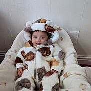 Maghathi joined the competition — help win amazing prizes! baby, child, onesie, fluffy_clothing, bear_ears, blanket, soft_texture, infant, cute, smiling, face, person, indoor, cozy, warm_clothing, patterned_fabric, lying_down, headwear, hands, feet