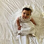 Luna participe au concours pour gagner de l'argent avec cette photo : baby, child, white_dress, headband, flower_crown, sitting, bed, white_bedspread, adorable, portrait, cute, infant, looking_up, hands, feet, indoors, soft_lighting, fabric, young_child, smile