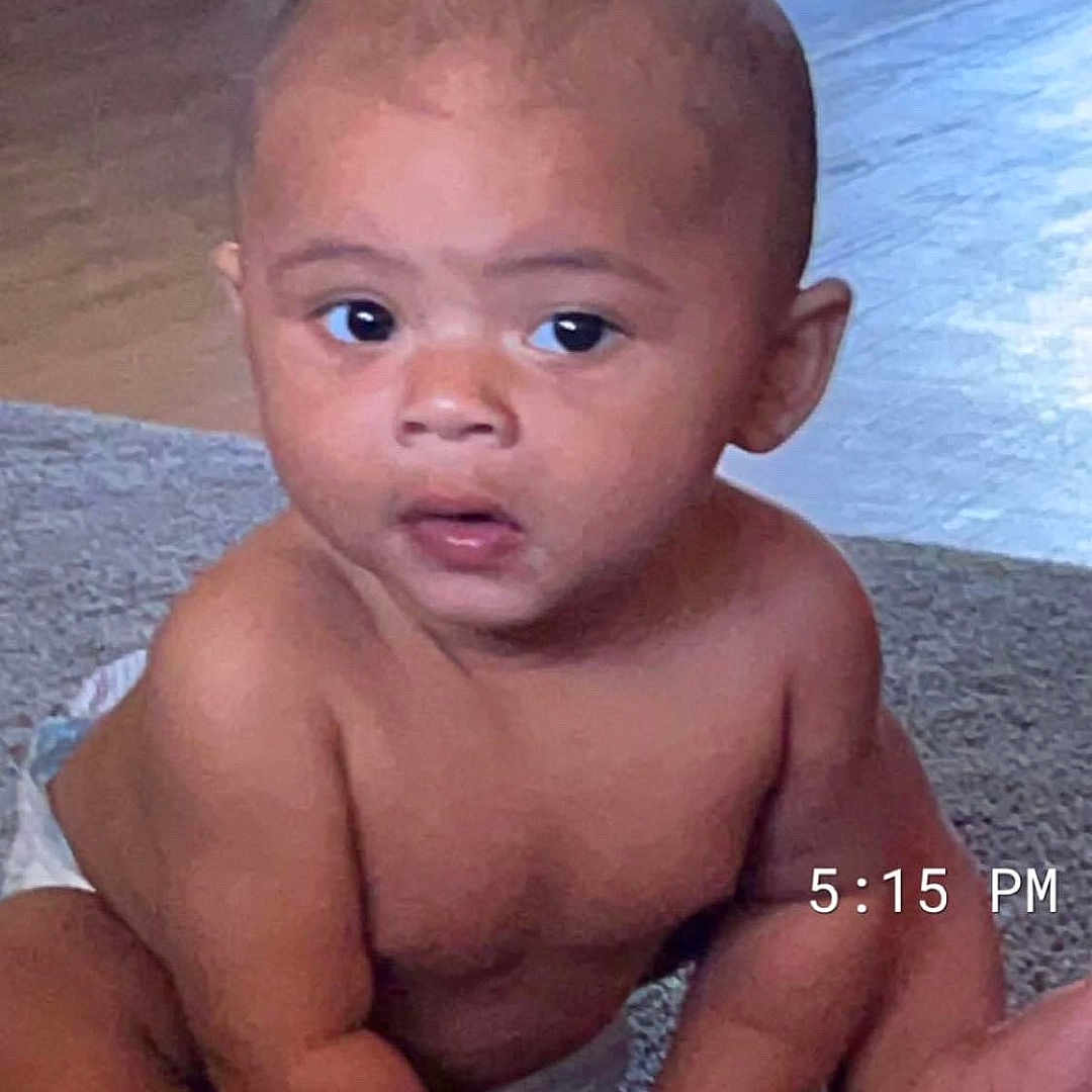 Karter is registered to the contest to win money with this photo: advertisement, baby, beach, bodypart, coast, crawling, diaper, face, head, nature, newborn, outdoors, person, photography, portrait, poster, sea, shoreline, sitting, water