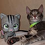 cat, kitten, toy_cat, figurine, green_collar, tabby, paw, indoor, pet, animal, cute, soft_surface, playful, close_up, brown, gray, striped, whiskers, ears, face