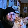 animal, artwork, beanie, cat, closeup, cozy, face, facial_hair, ginger_cat, glasses, home, indoor, lamp, man, pet, portrait, seated, white_cat, window, wooden_wall