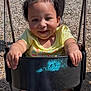adult, black_swing, casual_clothing, child, daylight, fun, grass, hair_ties, happy, outdoor, park, person, play, playground, recreation, smile, swing, toddler, woodchips, yellow_shirt