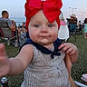 arm, baby, casual, child, crowd, cute, daylight, festival, grass, hand, headwear, infant, outdoor, people, portrait, reaching, red_bow, striped_clothing, summer, tattoo