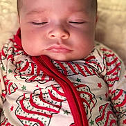 Heidi joined the competition — help win amazing prizes! baby, sleeping, close_up, face, onesie, clothing, red, green, pattern, holiday, festive, infant, soft_skin, peaceful, cute, portrait, child, indoors, newborn, relaxed