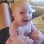 Zane joined the competition — help win amazing prizes! baby, smiling, hands, legs, adult_hands, living_room, sofa, lamp, table, couch, happy, indoor, person, blur, skin, playful, furniture, child, home, infant