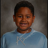 Zayden joined the competition — help win amazing prizes! child, boy, smile, missing_teeth, portrait, blue_shirt, curly_hair, studio_photo, watermark, head_and_shoulders, happy, casual_clothing, indoor, neutral_background, person, young, cute, positive_expression, photography, face