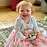 Zayleigh is registered to the contest to win money with this photo: toddler, child, smiling, indoor, carpet, toy, dress, pink, happy, cute, person, baby, playful, floor, curly_hair, long_sleeves, sitting, portrait, home, young_child