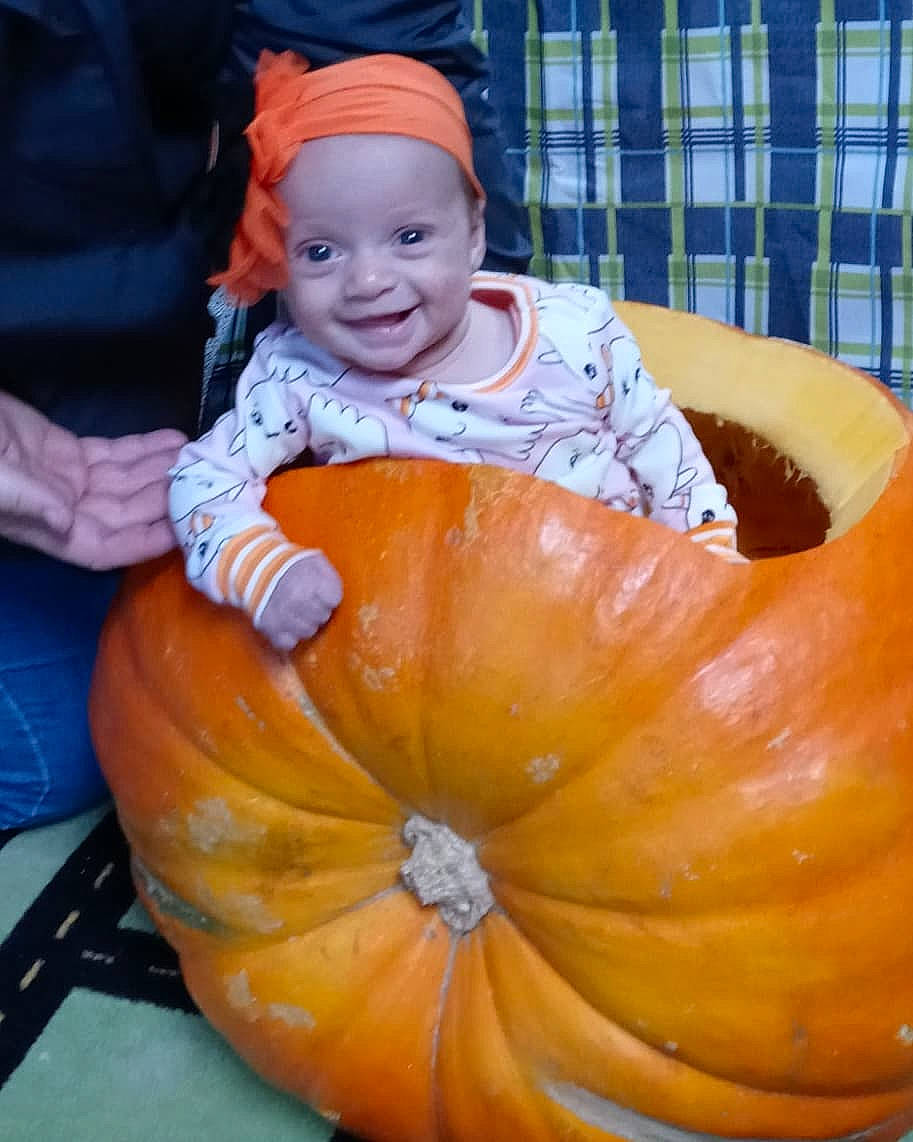 Mavis is registered to the contest to win money with this photo: baby_toddler_clothing, calabaza, cucurbita, eye, facial_expression, fruit, gourd, happy, head, headwear, human_body, joy, natural_foods, orange, organ, person, plant, pumpkin, smile, squash