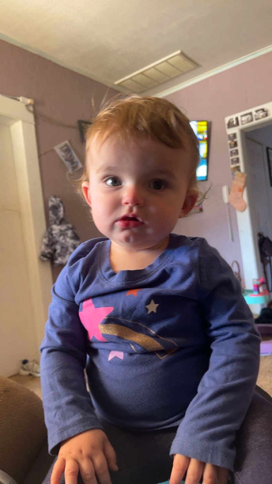 Charlotte Rork joined the competition — help win amazing prizes! toddler, child, indoor, person, blue_shirt, long_sleeve, hands, face, hair, curious, seated, furniture, coat, picture_frame, doorway, carpet, home, casual, young_child, portrait