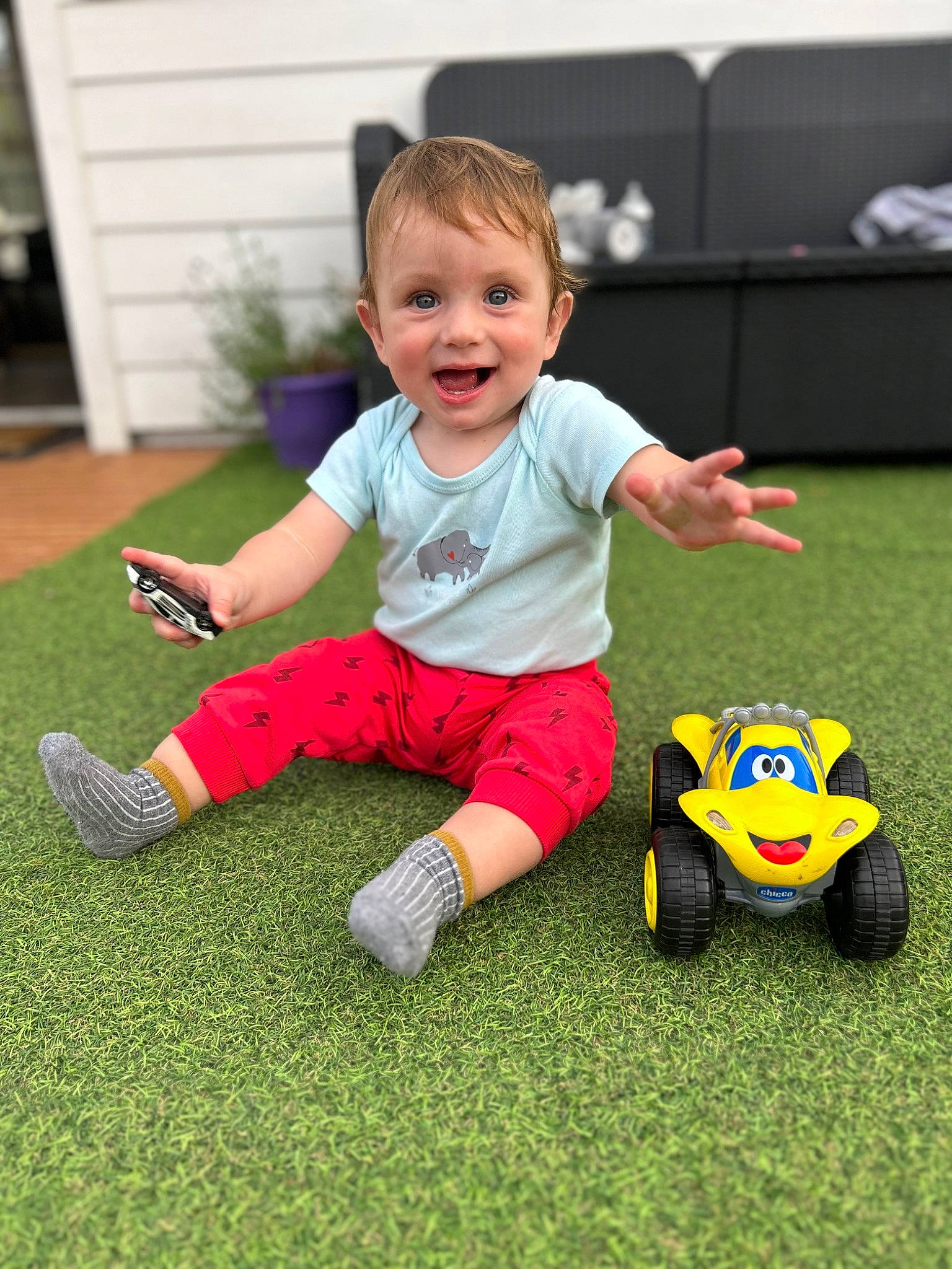 Ismael participe au concours pour gagner de l'argent avec cette photo : automotive_tire, baby_toddler_clothing, child, flooring, football, fun, grass, happy, joy, lawn, leisure, person, plant, riding_toy, shorts, smile, tire, toddler, toy, vehicle