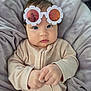Evelyn is registered to the contest to win money with this photo: baby, child, sunglasses, flower_shaped, blue_eyes, cozy, blanket, soft, cute, portrait, infant, clothing, pink, hands, reflection, close_up, indoor, face, person, sleepwear