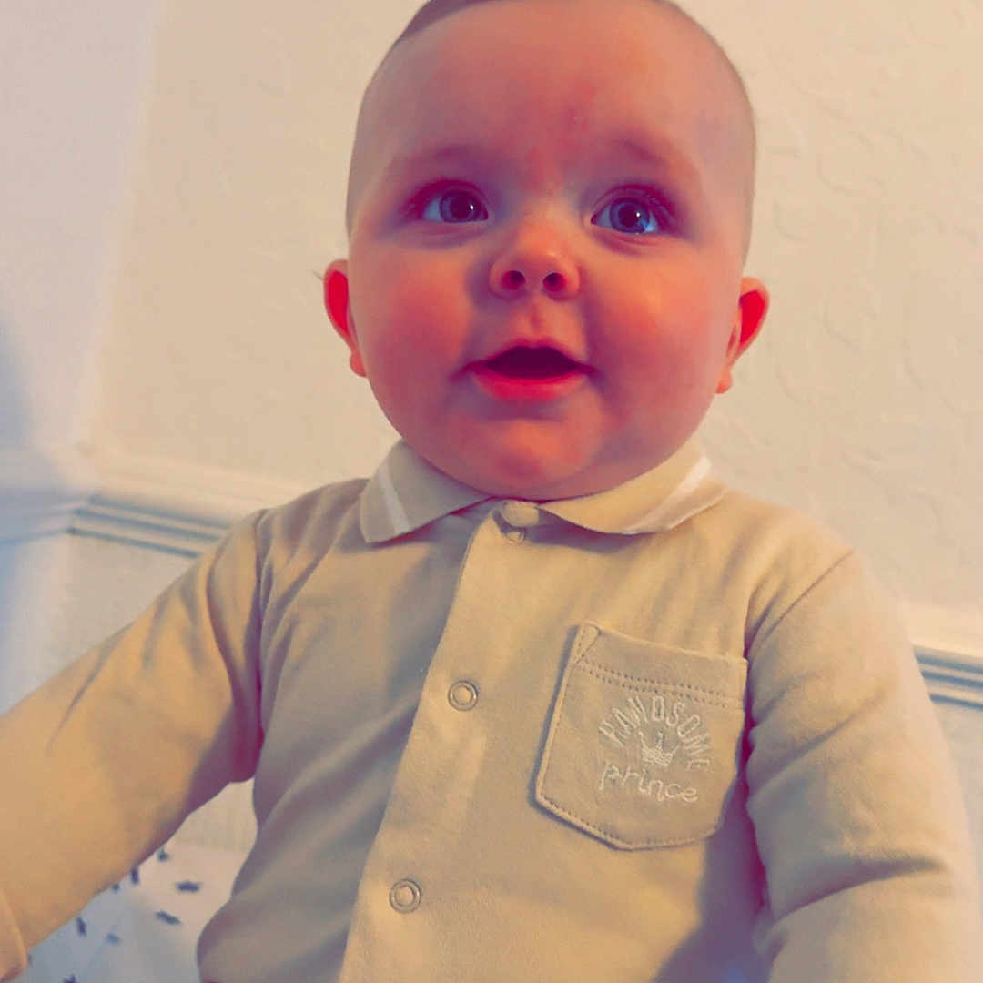 Arlo-David is registered to the contest to win money with this photo: baby, bodypart, clothing, face, finger, hand, happy, head, longsleeve, newborn, pants, pattern, person, photography, portrait, shirt, sitting, sleeve, smile, wood