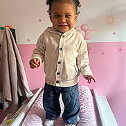 Mahyna a rejoint le concours — aidez-le/la à gagner de superbes lots ! child, toddler, smile, standing, nursery, changing_table, pink, hoodie, jeans, sneakers, pigtails, hair_buns, wall_stickers, stars, balloons, sun, towel, indoor, happy, portrait