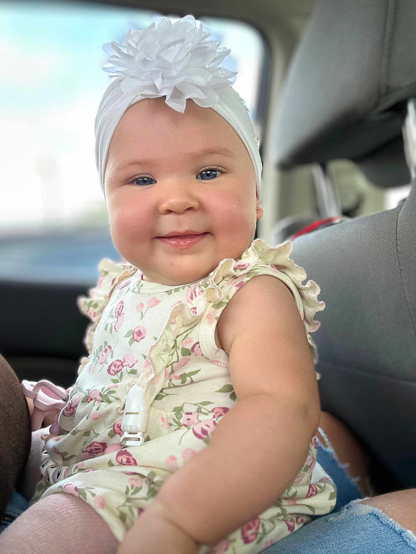Cattaleya joined the competition — help win amazing prizes! baby, child, smile, headband, flower, dress, floral, ruffles, car_seat, seat, clothing, person, cheeks, skin, arm, indoor, window, seatbelt, happy, portrait