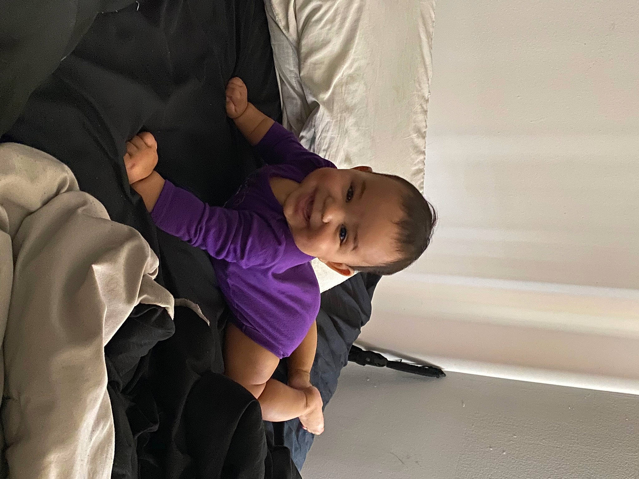 Ivy is registered to the contest to win money with this photo: baby, baby_products, child, comfort, event, flooring, formal_wear, fun, gesture, happy, joy, luxury_vehicle, person, room, sandal, sitting, suit, thumb, toddler