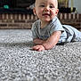 baby, child, smiling, carpet, gray_shirt, indoor, face, tongue_out, cute, happy, infant, person, home, floor, portrait, young_child, earrings, crawling, soft_texture, background_blur