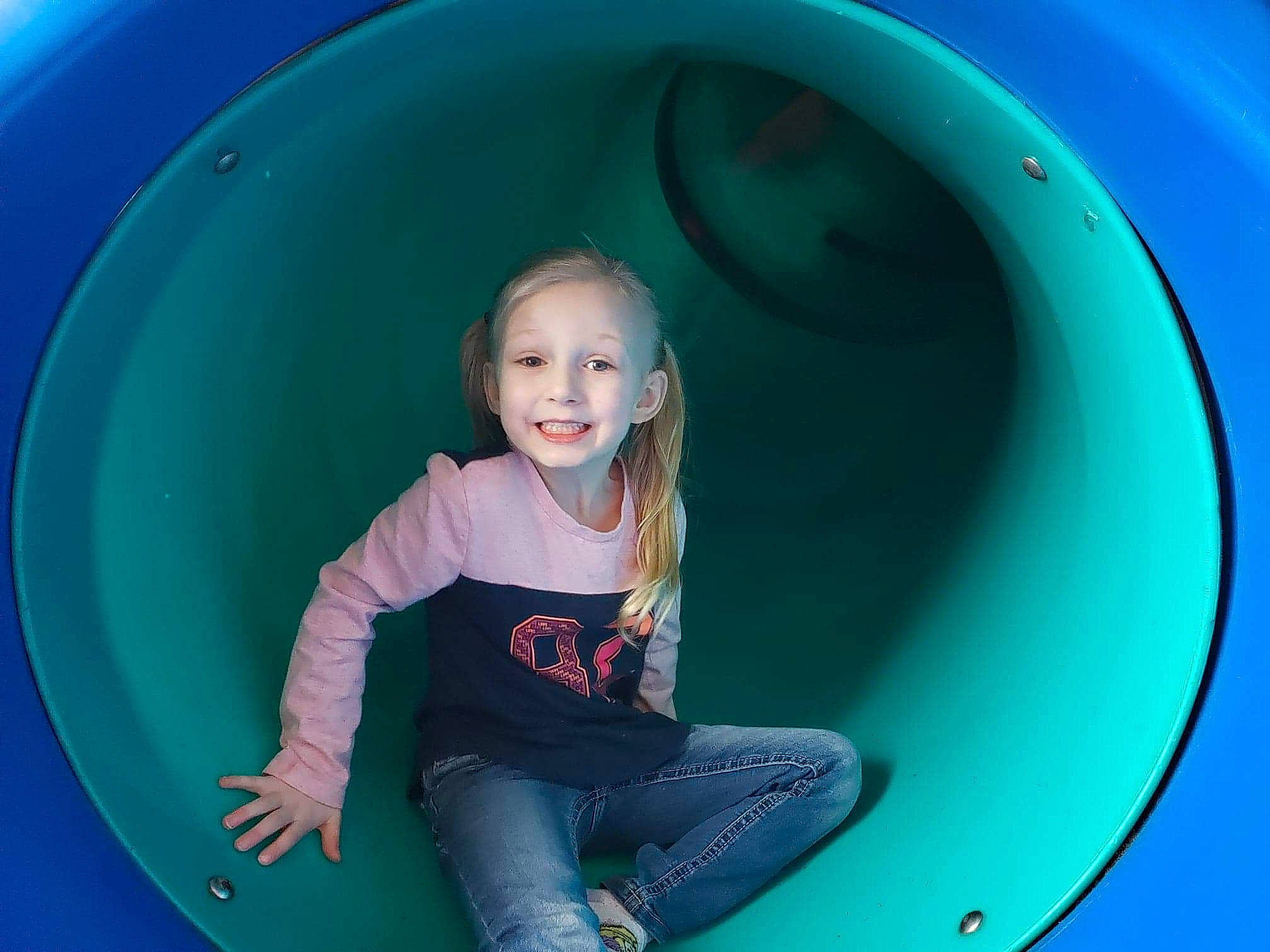 Sadie is registered to the contest to win money with this photo: blue, child, circle, eye, fun, games, green, inflatable, joy, leisure, outdoor_play_equipment, person, photography, play, playground, recreation, sitting, smile, toddler