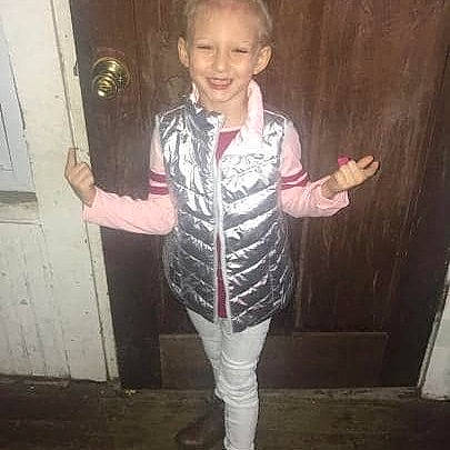 Sadie is registered to the contest to win money with this photo: child, child_model, finger, footwear, gesture, jacket, joy, outerwear, person, shoe, sleeve, standing, thumb, toddler