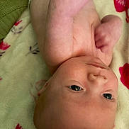 Karsyn joined the competition — help win amazing prizes! baby, infant, child, face, eyes, wide_eyed, lying_down, upside_down, fists, hands, blanket, bedding, floral_pattern, indoor, portrait, close_up, fair_skin, cozy, alert, photograph