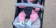 Harper is registered to the contest to win money with this photo: baby, stroller, sunglasses, headband, pink_clothing, sneakers, outdoor, child, footwear, pavement, seat, straps, sunshade, person, casual, accessory, walking_path, cute, infant, fashion