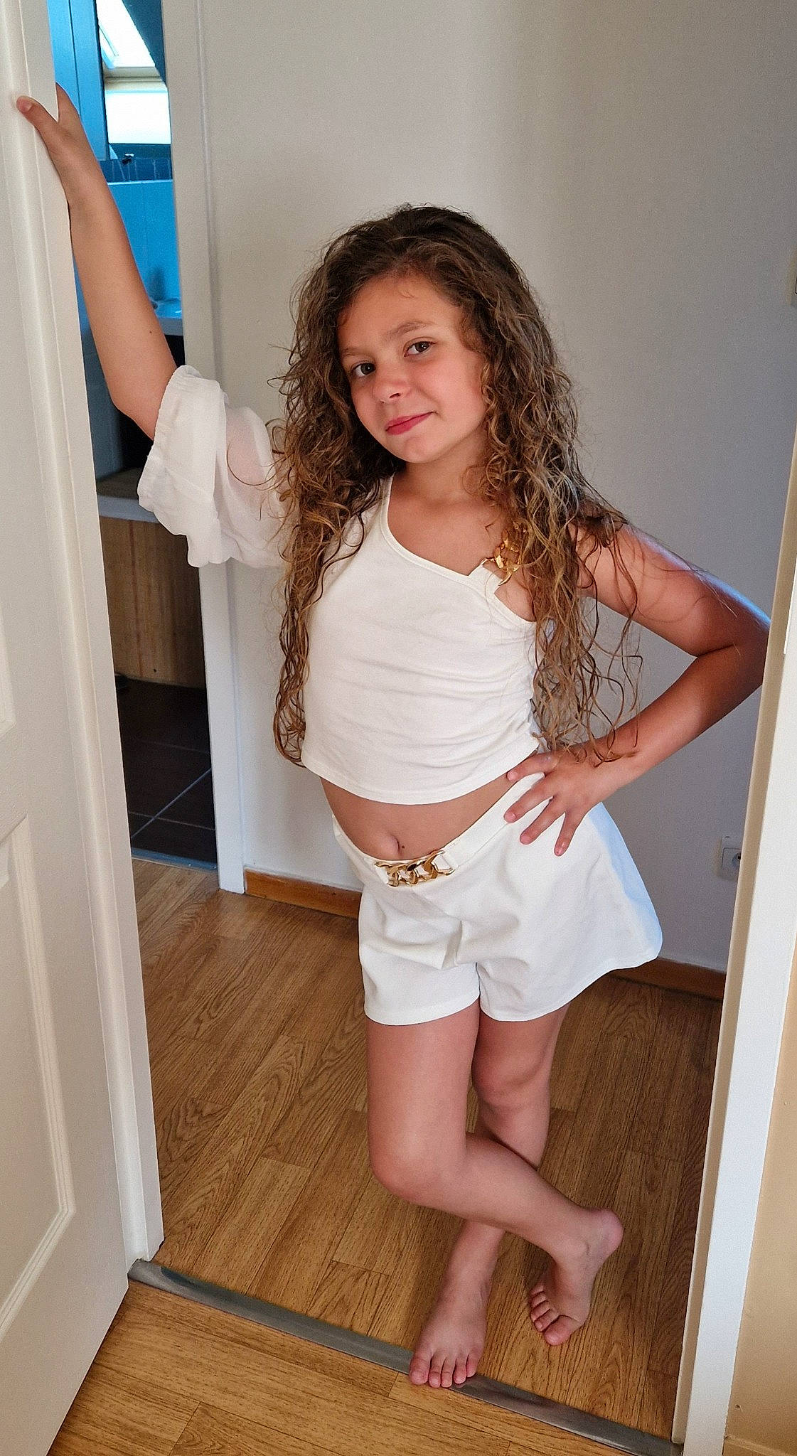 Louna participe au concours pour gagner de l'argent avec cette photo : abdomen, blond, brown_hair, flash_photography, hardwood, human_body, human_leg, joint, joy, knee, long_hair, person, shorts, shoulder, sleeve, smile, standing, stomach, thigh, trunk