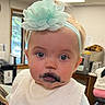 Mallory is registered to the contest to win money with this photo: baby, child, headband, flower, bib, face, mouth, blue_eyes, indoor, person, clothing, cute, expression, smudge, infant, portrait, light, window, furniture, room