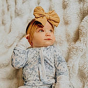 Brinley is registered to the contest to win money with this photo: baby, child, infant, headband, bow, floral_pajamas, blanket, soft_texture, portrait, face, cute, cozy, indoor, lying_down, hand, expression, young_child, closeup, sleepwear, comfort