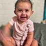 baby, child, smiling, pink_clothing, sitting, indoor, cute, happy, face, infant, person, skin, hand, foot, pacifier_clip, short_hair, playful, blur, light, background