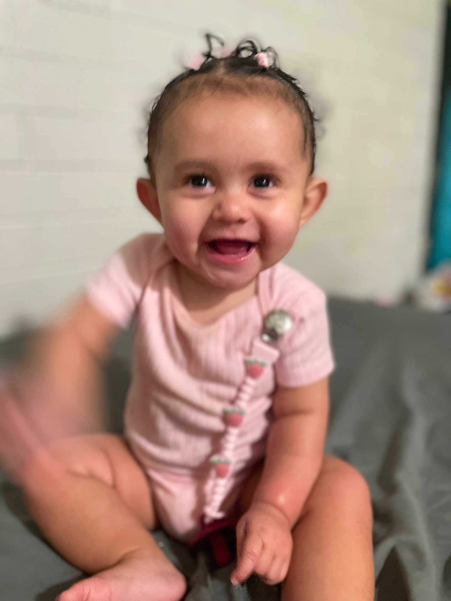 Miracle joined the competition — help win amazing prizes! baby, child, smiling, pink_clothing, sitting, indoor, cute, happy, face, infant, person, skin, hand, foot, pacifier_clip, short_hair, playful, blur, light, background