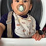 Beau joined the competition — help win amazing prizes! baby, bib, child, clothing, cute, expression, face, feeding, furniture, hand, high_chair, indoor, infant, looking, pacifier, person, seatbelt, sitting, table, young