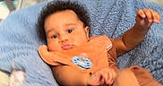 Wysdom is registered to the contest to win money with this photo: baby, infant, blanket, blue_blanket, bib, pacifier, brown_clothing, indoor, furniture, floor, child, person, cute, blur, soft_texture, crawling, young_child, head, face, arm