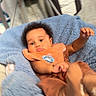 baby, infant, blanket, blue_blanket, bib, pacifier, brown_clothing, indoor, furniture, floor, child, person, cute, blur, soft_texture, crawling, young_child, head, face, arm
