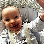 Milo participe au concours pour gagner de l'argent avec cette photo : baby, child, face, messy_face, berry_stains, high_chair, harness, grey_shirt, reaching_hand, smiling, happy, indoor, cushion, fabric, closeup, portrait, infant, cute, expression, skin