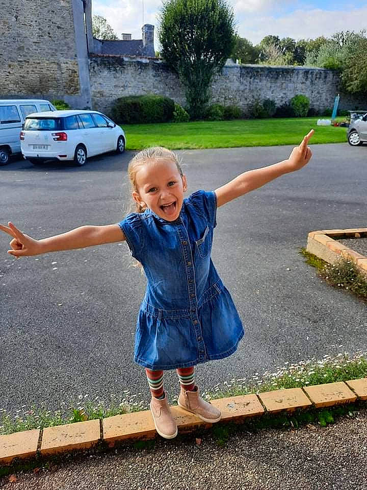 Louana a rejoint le concours — aidez-le/la à gagner de superbes lots ! asphalt, blue, car, gesture, grass, happy, infrastructure, joy, line, people_in_nature, person, plant, public_space, road_surface, sky, smile, standing, tire, toddler, tree