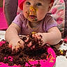 baby, child, high_chair, cake, chocolate, messy, pink_hat, pink_plate, birthday, celebration, balloon, face_paint, food, smiling, indoor, table, person, cute, toddler, fun