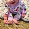 baby, child, smiling, headband, bow, floral_clothing, onesie, cushion, carpet, indoor, happy, cute, sitting, infant, portrait, person, floor, pink, purple, home