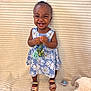 toddler, child, smiling, flower, dress, blue, floral_pattern, sandals, toy, plush_toy, teddy_bear, happy, indoors, cute, person, standing, young_child, accessory, joyful, background