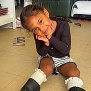 Zendaya participe au concours pour gagner de l'argent avec cette photo : armchair, boots, braids, casual, child, cute, floor, furniture, girl, happy, home, indoor, living_room, play, portrait, shorts, smile, socks, sweater, toy
