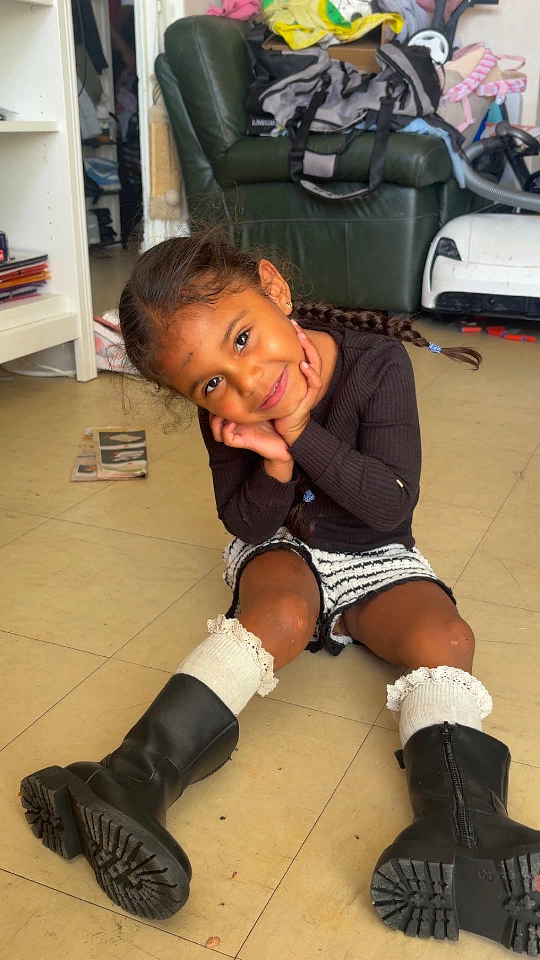 Zendaya participe au concours pour gagner de l'argent avec cette photo : armchair, boots, braids, casual, child, cute, floor, furniture, girl, happy, home, indoor, living_room, play, portrait, shorts, smile, socks, sweater, toy