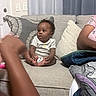 Kenzo joined the competition — help win amazing prizes! baby, child, couch, pillow, curtain, living_room, person, infant, sitting, clothing, arm, door, home_interior, fabric, blanket, pattern, wall, door_handle, smile, indoor