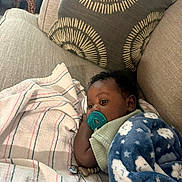 Kenzo joined the competition — help win amazing prizes! baby, pacifier, blanket, couch, pillow, striped_cloth, giraffe_figurine, indoor, child, infant, resting, cozy, soft, blue, beige, pattern, comfort, cute, young, portrait