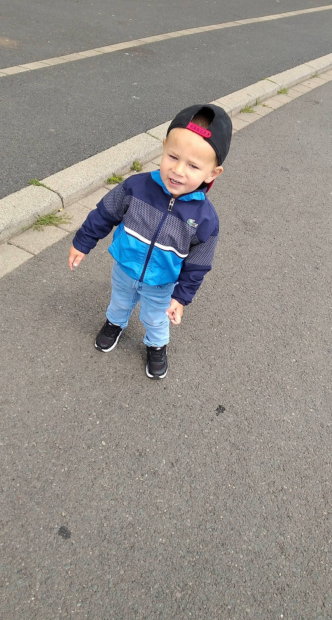 Rayan participe au concours pour gagner de l'argent avec cette photo : asphalt, child, denim, electric_blue, footwear, fun, headwear, jeans, outerwear, person, play, shoe, smile, toddler