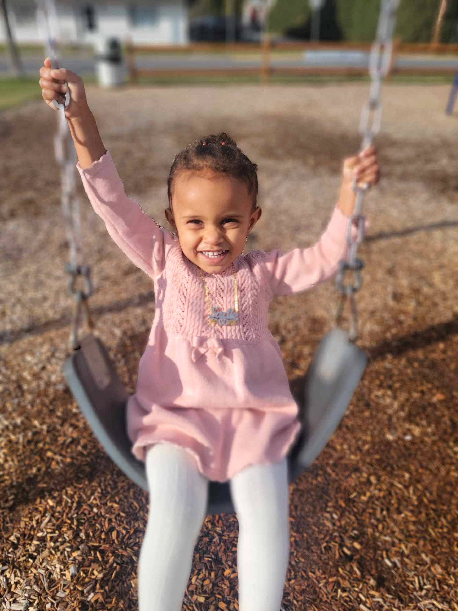 Sadie is registered to the contest to win money with this photo: city, eye, facial_expression, finger, fun, gesture, grass, hair, hairstyle, happy, joy, leaf, leisure, people_in_nature, person, pink, plant, recreation, sleeve, smile